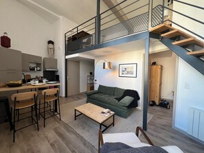 Eine Loft-Wohnung mit Küche, Essbereich und Wohnzimmer.