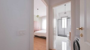 Ein modernes Badezimmer mit Duschkabine aus Glas, Toilette und Waschmaschine.