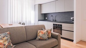 Eine moderne Küche mit schwarzer Arbeitsplatte, weißen Schränken und einem schwarzen Wasserhahn.