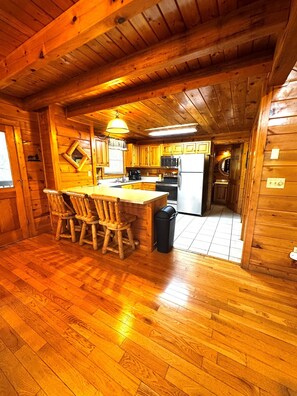 L’intérieur d’un chalet en bois comprend une cuisine, un coin repas et une petite salle de bain.