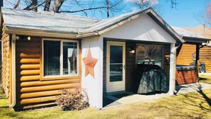A log cabin with a star decoration, a garage, and a covered outdoor area. - Serene 2-bedroom cabin on The Provo River (Provo)