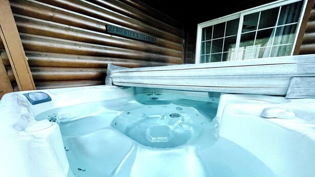 A hot tub with a control panel, a wooden wall, and a window. - Serene 2-bedroom cabin on The Provo River (Provo)