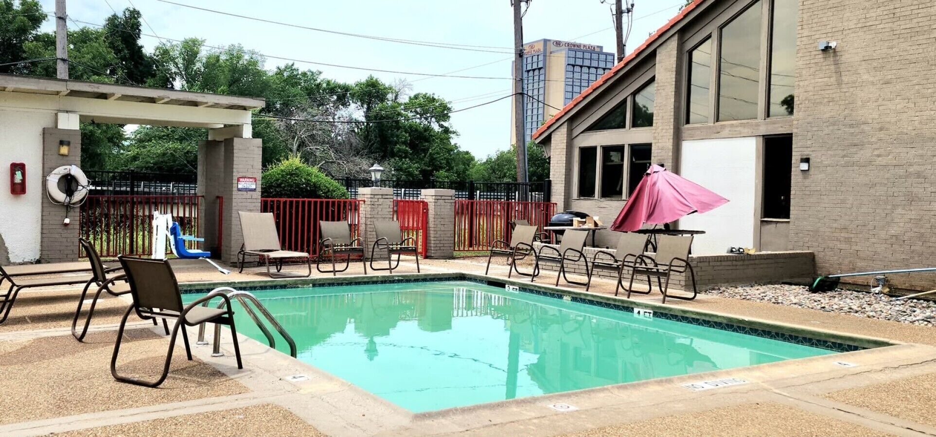 A swimming pool with lounge chairs and a covered seating area.