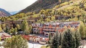 A mountain town with red-roofed buildings, a ski lift, and a forested hillside. - Perfect condo in enchanting Aspen for your next getaway (Aspen)