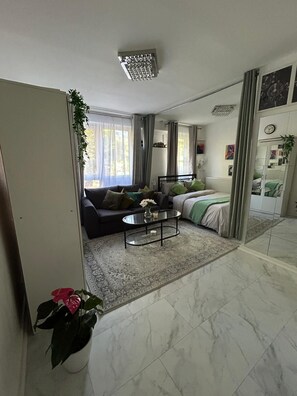 A modern living room with a sofa, a coffee table, and a bed.