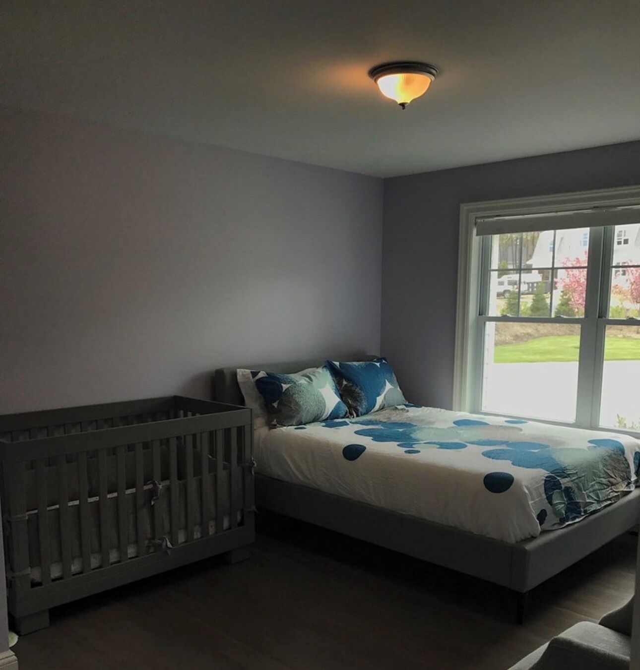 A bedroom with a bed, a window, and a radiator.