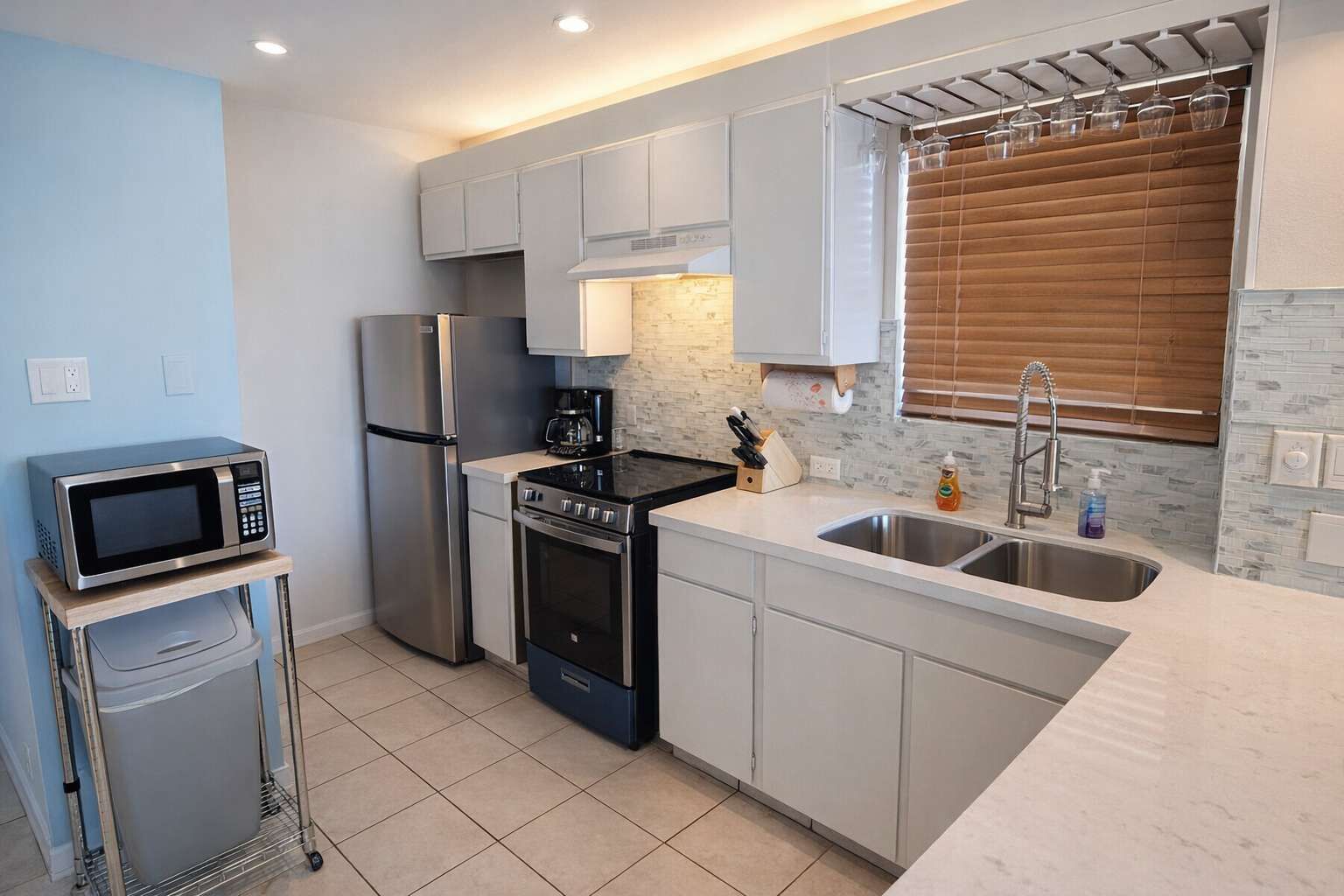 A modern kitchen with stainless steel appliances, a built-in oven, and a double sink.