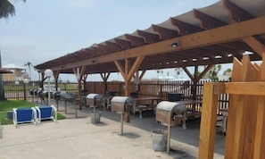 Un espacio al aire libre cubierto con bancos de madera, buzones y un cerramiento.