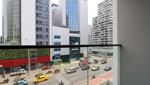 Vista de una calle urbana con edificios altos, un taxi y un ciclista.