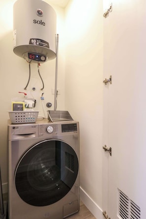 A laundry area with a washing machine, a dryer, and a water heater. - w* | Amazing & Chic 1BR w/ Balcony in San Isidro (San Isidro)