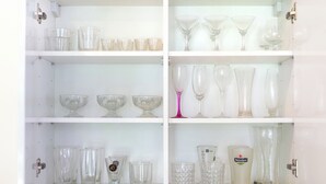 A cabinet with shelves containing various glassware, including shot glasses, goblets, and wine glasses. - Tropical Pool Villa with 3 Bedrooms in Rawai (Tambon Rawai)