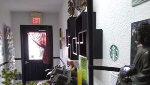 A hallway with an exit sign, a statue, and a Starbucks sign on the wall. - The Orca Inn (Friday Harbor)