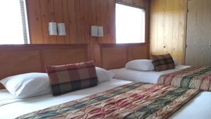 A room with two beds, wooden walls, and a window. - The Orca Inn (Friday Harbor)