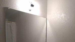 A bathroom with a white sink, a mirror, and a towel rack.