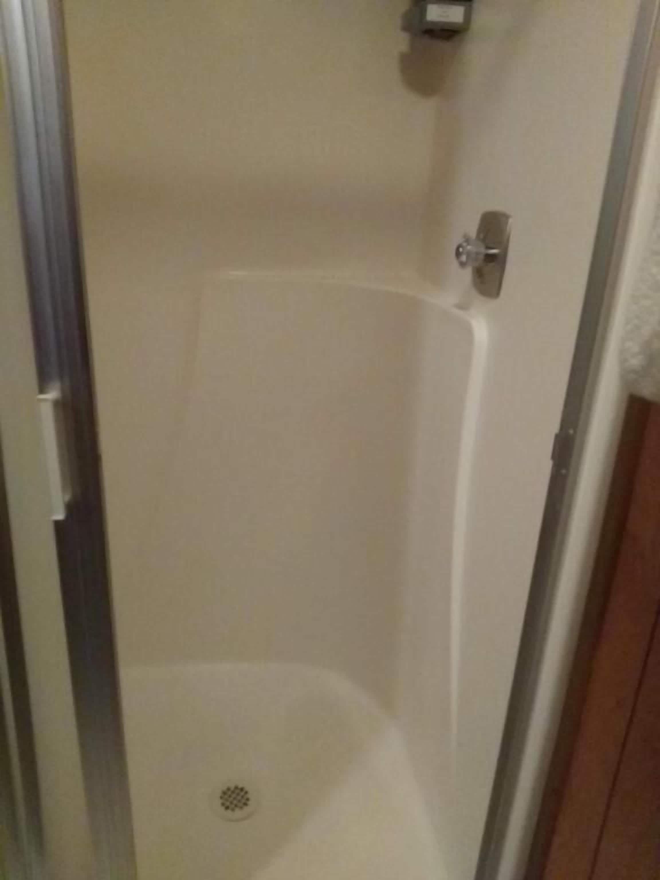 Ducha con desagüe, puerta y barra para toallas.