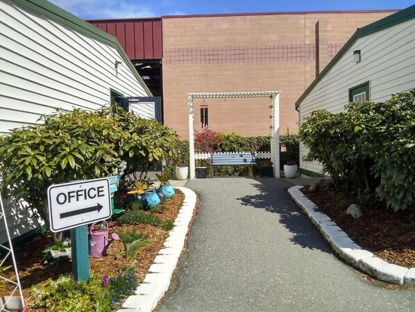 A pathway leading to an office area with a sign indicating the direction. - The Orca Inn (Friday Harbor)