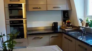 Una cocina moderna con electrodomésticos integrados, encimera y ventana.