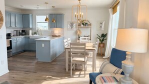 A modern kitchen with blue cabinets, a central island, and pendant lighting. - Show Me Carolina, Steps to Beach, Pet Friendl (Topsail Beach)