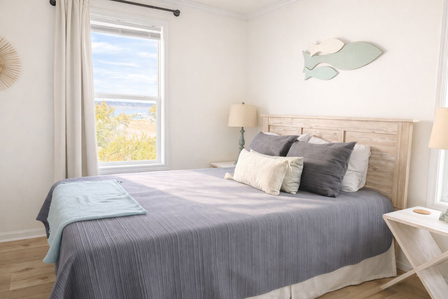 Une chambre à coucher avec un lit, une fenêtre avec des rideaux, une table de chevet et un élément décoratif mural.