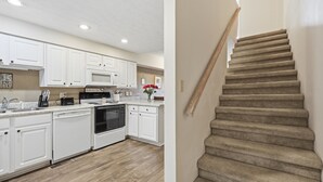 A modern kitchen with white cabinets, a microwave, and a stove.