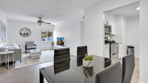 Una sala de estar moderna con comedor, cocina y vistas al exterior.