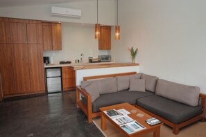 A modern kitchen with wooden cabinets, a built-in oven, and a coffee maker. - Ocean View Studio at Taru Rentals (Montezuma)
