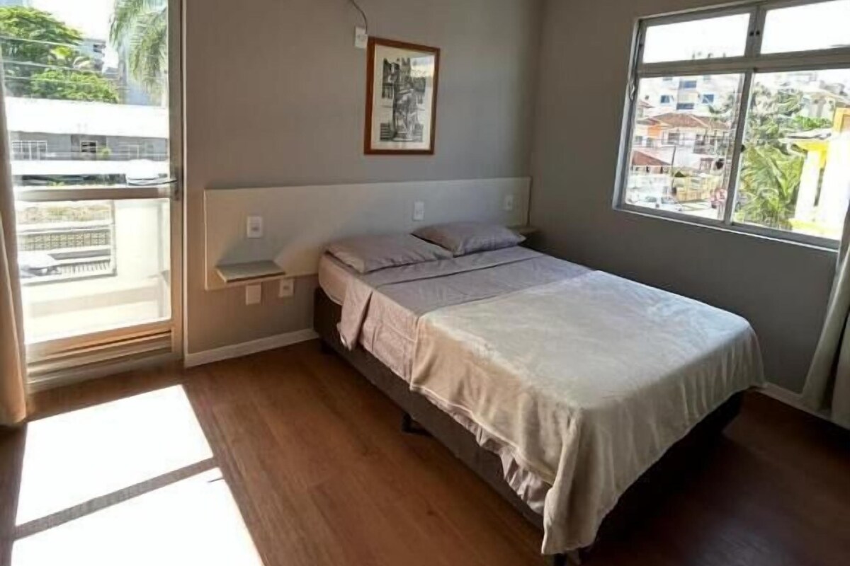 Una camera da letto con un letto, una finestra e un condizionatore d'aria.