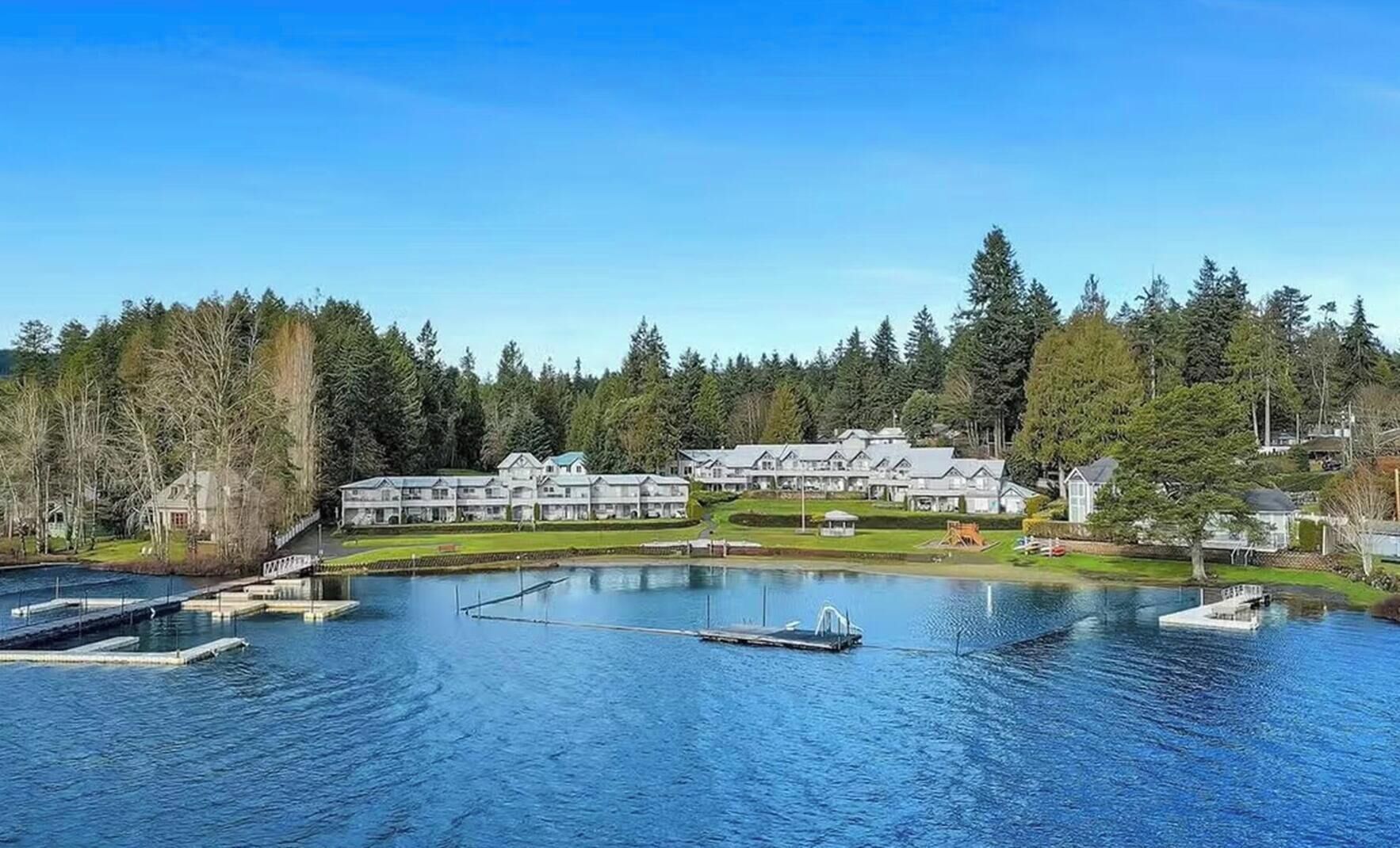 A resort with multiple buildings, a large lake, and docked boats.