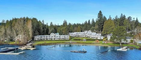 A resort with multiple buildings, a large lake, and docked boats.