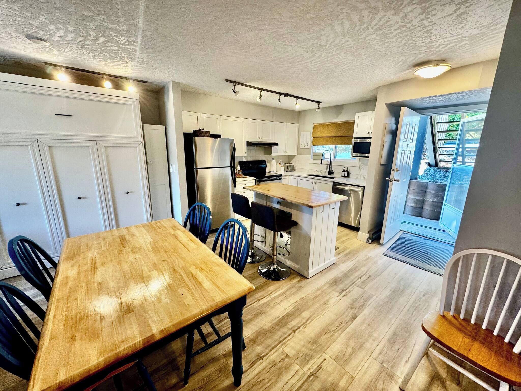 A compact kitchen with a dining area, a built-in island, and a view of the outdoors.