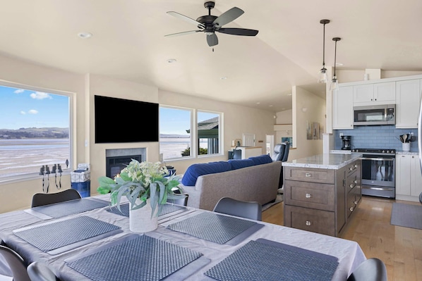 A modern kitchen with a microwave, stove, and dining area with a table set for four.