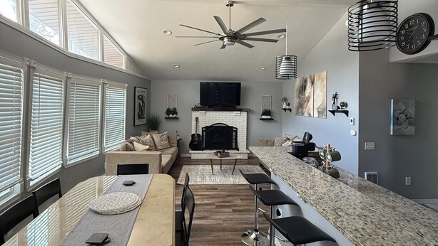 A modern kitchen with a dining area, a fireplace, and a ceiling fan. - Cozy home just a minute walk from the lake! (Tobyhanna)