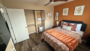 A bedroom with a bed, a ceiling fan, a walk-in closet, and a nightstand with a lamp. - Cozy home just a minute walk from the lake! (Tobyhanna)