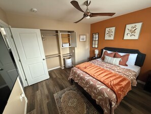 A bedroom with a bed, a ceiling fan, a walk-in closet, and a nightstand with a lamp. - Cozy home just a minute walk from the lake! (Tobyhanna)