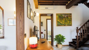 A wooden reception desk with a lamp, a potted plant, and a painting on the wall. - 2-bedroom condo in peaceful Lucca with air conditioning and assigned parking (Lucca)