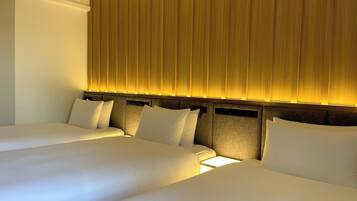 A hotel room with two beds, a headboard with vertical lines, and a light source behind the headboard.