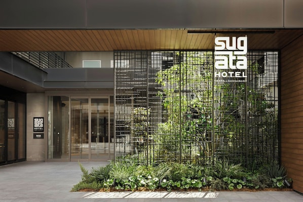 A modern hotel entrance with a vertical garden and a sign for Sugata Hotel. - Sugata Hotel Osaka Shinsaibashi, Series By Marriott (Osaka)