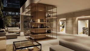 Een modern interieur met een centraal wandrek, banken, een glazen salontafel en een muur met een logo.