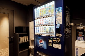 A vending machine with various drink options, a Pepsi logo, and a coffee machine labeled 'SUNTORY'. - Sugata Hotel Osaka Shinsaibashi, Series By Marriott (Osaka)