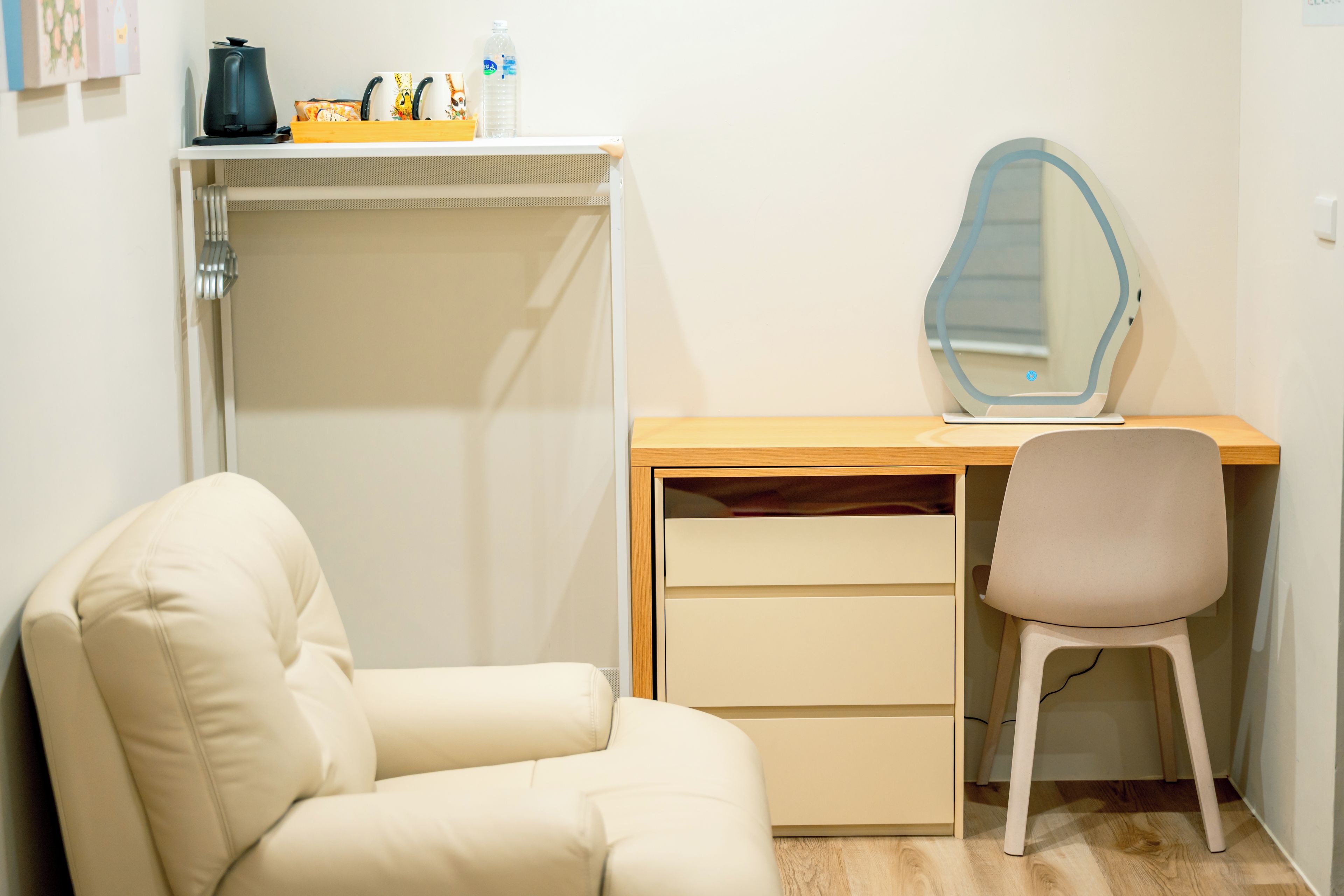 Un dormitorio con cama, escritorio con silla, espejo y armario.