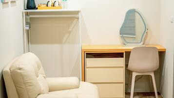 Un dormitorio con cama, escritorio con silla, espejo y armario.