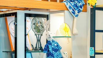 Une exposition de divers objets décoratifs, notamment une figurine de paon, une horloge et un mannequin portant une tenue bleue.