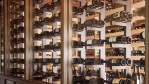 Una bodega con varias filas de botellas de vino en estanterías.