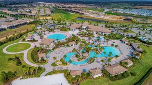 Ein Resort mit mehreren Schwimmbecken, einem Golfplatz und einem großen Parkplatz.