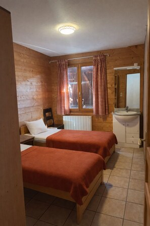 A room with two beds, a window with checkered curtains, a sink, and a mirror. - Andreas Large Vacation Rental ★ Sleeps 15   ★ 50 m from the slopes ★ Terrace ★ Les Sybelles (Saint-Sorlin-d'Arves)