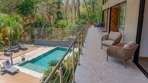 Ein moderner Außenbereich mit Schwimmbad, Liegestühlen und einer Holzterrasse.