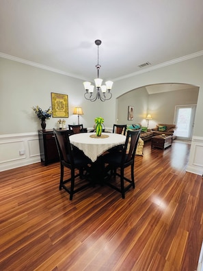A dining area with a round table, chairs, a chandelier, and a vase with flowers. - 5 miles from Augusta National. MASTERS (Augusta)