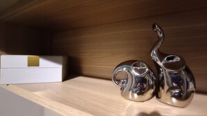Een houten plank met een witte doos en twee metalen theepotten.