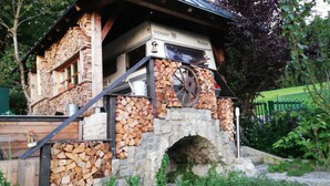 A stone building with a chimney, a wooden staircase, and a metal sign. - Charming Mobile Home Retreat in Ebbs, Austria - Tranquil Escape (Ebbs)