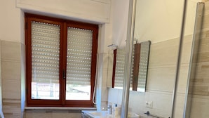 Ένα σύγχρονο μπάνιο με τουαλέτα, νιπτήρα και ντους.